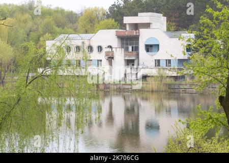 Chisinau, Moldova - April 20 2022 - An abandoned white building in front of a lake in the spring Stock Photo