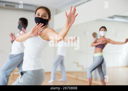 Group of multinational people in protective masks practicing dance techniques Stock Photo