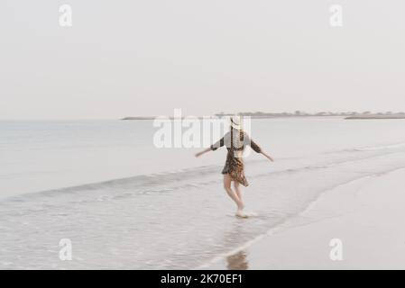 Young woman in a hat and beachwear the beach, motion effect Stock Photo