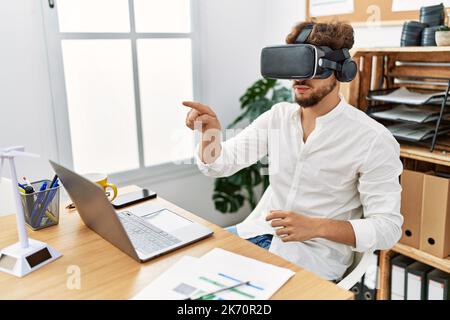 Young arab man using vr goggles working at office Stock Photo