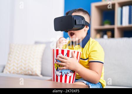 Adorable hispanic boy watching 3d movie sititng on sofa at home Stock Photo