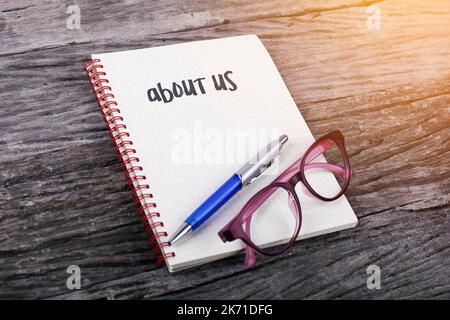 Note with about us on the wooden background Stock Photo