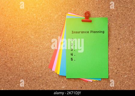 Insurance Planning written on color sticker notes over cork board background Stock Photo