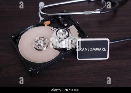 A stethoscope scanning for lost information on a hard drive disc with RANSOMWARE word on board Stock Photo