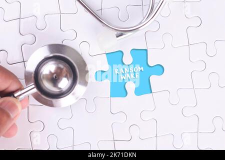 Doctor holding a Stethoscope on missing puzzle WITH RANSOMWARE WORD Stock Photo