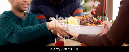 Happy family with mother served roasted turkey on Christmas holiday at home, thanksgiving eve, woman preparing food for celebrating and dinner with fa Stock Photo