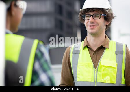 Young man and woman is architect planning and inspector project and scheme at construction site, engineer male and female working and examining for de Stock Photo