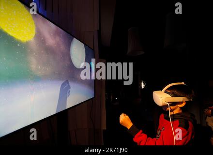 Bucharest, Romania. 16th Oct, 2022. A boy experiences virtual reality goggles while visiting the 3rd edition of the new media art festival RADAR in Bucharest, capital of Romania, Oct. 16, 2022. Credit: Cristian Cristel/Xinhua/Alamy Live News Stock Photo