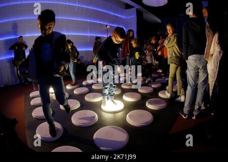 Bucharest, Romania. 16th Oct, 2022. Children jump over a light installation while visiting the 3rd edition of the new media art festival RADAR in Bucharest, capital of Romania, Oct. 16, 2022. Credit: Cristian Cristel/Xinhua/Alamy Live News Stock Photo