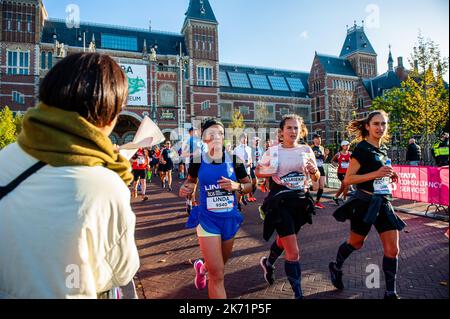 A woman in the audience is seen cheering the participants. More than 18,000 fanatics, a record number, ran the classic distance of over 42 kilometers this Sunday during the 46th edition of the TCS Amsterdam Marathon. This run is a World Athletics Platinum Label Road Race that for years has had one of the fastest courses in the world. The increase in the number of foreign participants is striking, more than half of the entire marathon runners come from outside the Netherlands. Ethiopian athlete Almaz Ayana broke the course record in Amsterdam on her marathon debut, crossing the finish line in 2 Stock Photo