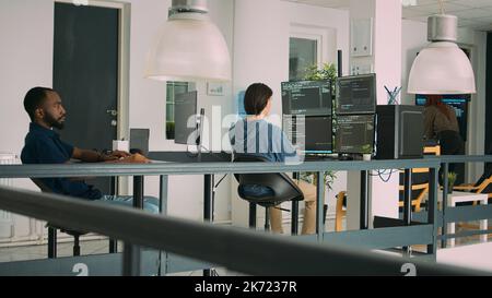 Diverse artificial intelligence programers typing system code and programming firewall server on multiple screens. IT developers working with coding algorithms, learning html language. Stock Photo