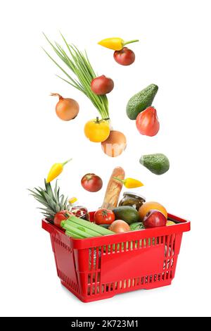 Many healthy vegetables falling into shopping basket on white background Stock Photo
