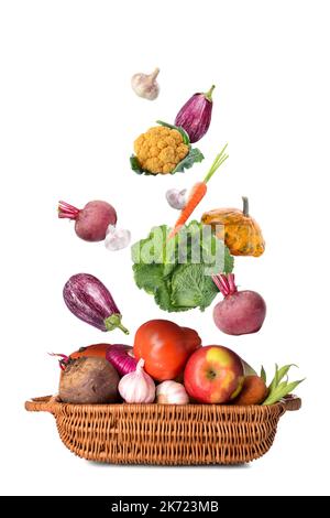 Many healthy vegetables falling into basket on white background Stock Photo