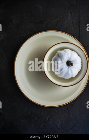 White pumpkin in table setting on dark concrete background Stock Photo