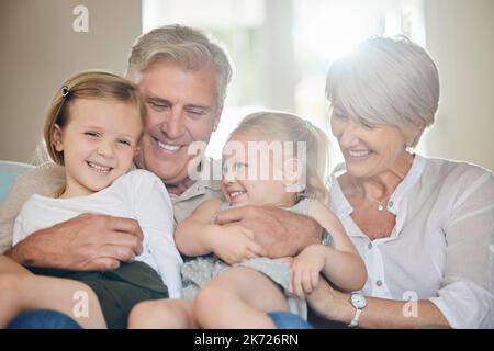 Happiness is having a large, loving family. grandparents spending time with their grandkids at home. Stock Photo