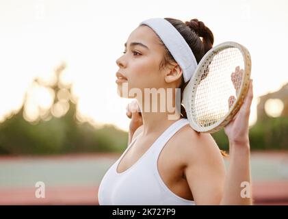 I know Im great now let me prove it. a sporty young woman posing with a tennis racket on a court. Stock Photo