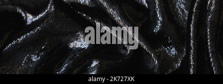 Closeup of tousled shiny black silk fabric closeup Stock Photo