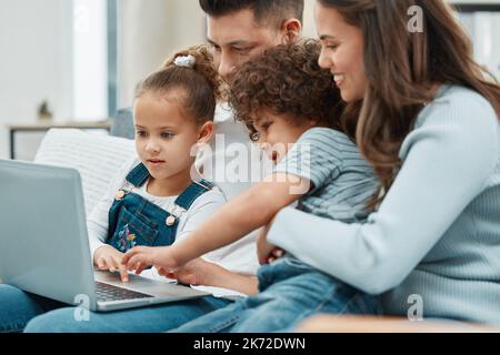 Saturdays are movie days. a young family spending time together while watching a film on their laptop. Stock Photo