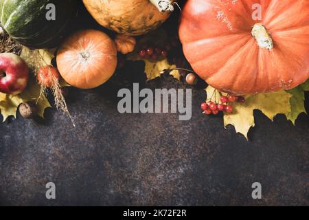 Thanksgiving day concept. Autumn table setting for dinner with plate, knife, fork decorated pumpkins and maple leaves. Flat lay autumn composition. Stock Photo