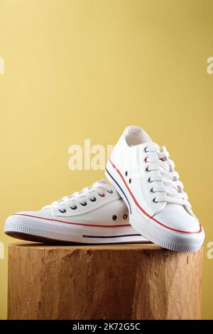 Pair of trendy shoes on yellow background. Sport sneakers with copy space, Summer footwear concept Stock Photo