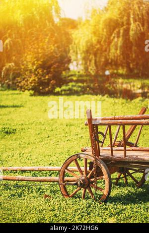 Garden Decoration Concept. Decorative Garden Wagon On Summer Lawn. Bright Sunny Day. Gardening And Housekeeping. Vintage Cart On Summer Sunny Day Stock Photo