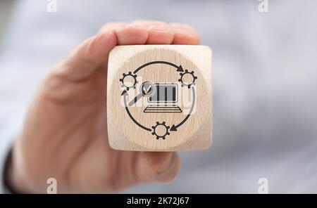 Hand holding a wooden cube with symbol of software update concept Stock Photo