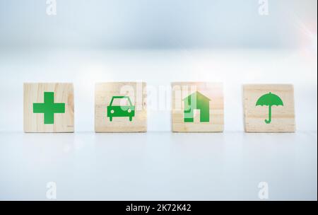 An insurance plan tailor made for you. wooden blocks with insurance related symbols on them. Stock Photo