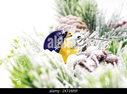 New Year's colorful background with a ball on which the flag of Bosnia and Herzegovina is depicted. The concept of the New Year holiday and Christmas. Stock Photo
