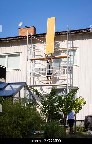 Men on scaffolding renovating house Stock Photo