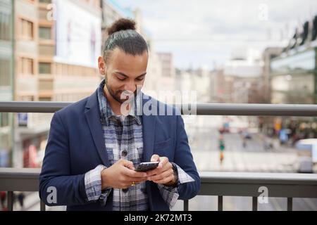 Smiling man using cell phone Stock Photo