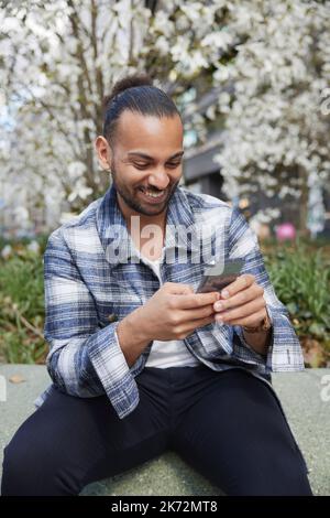 Smiling man using cell phone Stock Photo