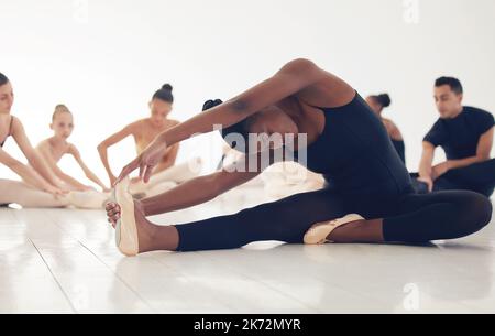 Dancers are the athletes of God. a group of ballerinas warming up before practicing their routine. Stock Photo