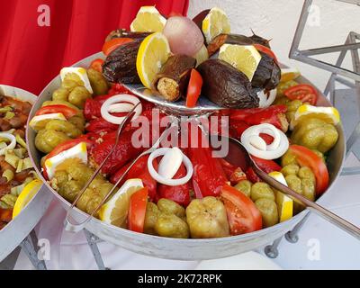 Stuffed pepper with rice and baked eggplants, garnished with lemon, tomatos and onion. Turkish national food Stock Photo