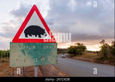 Sign in South Africa reminding drivers to beware of hippos crossing the road especially at night, with copy space Stock Photo