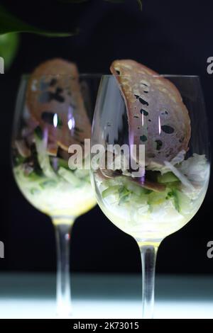 Fresh salad mix in cocktail glasses on black backgrounds closeup stock photo Stock Photo