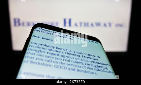 Smartphone with website of US holding company Berkshire Hathaway Inc. on screen in front of business logo. Focus on top-left of phone display. Stock Photo