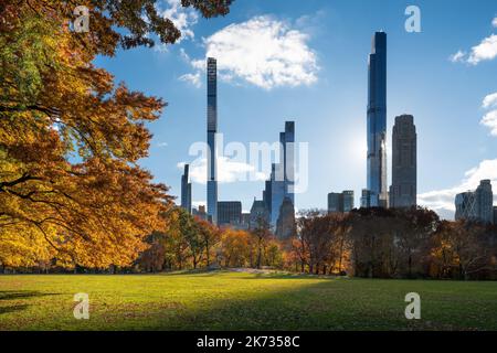 Central Park Sheep Meadow lawn in Fall with Billionaires Row skyscrapers. Midtown Manhattan, New York City Stock Photo