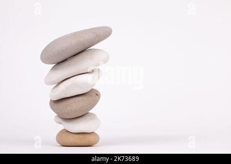 Reverse pebble zen columns with the smallest at the bottom isolated on white background Stock Photo