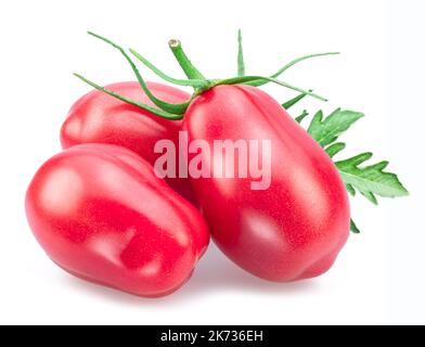Three pink tomatoes (plums) with tomato leaves isolated on white background. Stock Photo