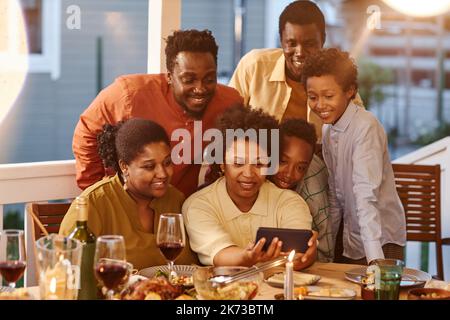 Portrait of African American family taking selfie photo at dinner in evening Stock Photo