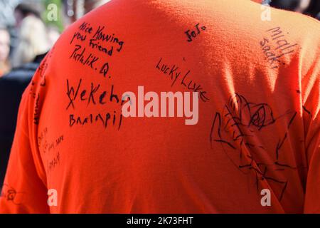 Montreal Canada (September 30, 2022): Protesters pay respect by signing 'Orange Day Shirt' of Indigenous man during the “Canada’s National Day for Truth & Reconciliation” that highlights the plight of the Indian Residential School childrens survivors. Stock Photo