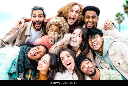 Multi cultural guys and girls taking best selfie outside on travel vacation - Happy life style friendship concept on young international people having Stock Photo