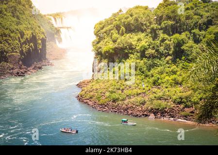 Detail of Iguazu Fall from mirador of Isla San Martin between argentinian and brazilian river side with motorboat dinghy  - Waterfalls nature wonder o Stock Photo