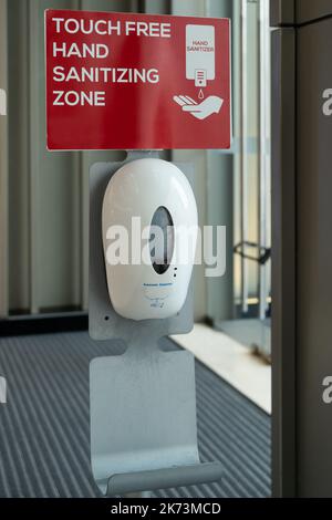 Touch free hand sanitizing soap gel automatic dispenser in the common place. Stock Photo