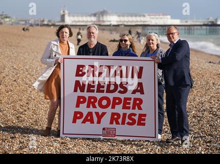 TUC General Secretary Frances O'Grady (left) with TUC Deputy General Secretary Paul Nowak (right) are joined by union representatives Ted Watson, Wilma Brown (middle) and Helen Johns, as they hold a placard on the beach in Brighton ahead of the TUC Congress in the city. Nowak will be confirmed as the union body's next General Secretary during Congress. Picture date: Monday October 17, 2022. Stock Photo