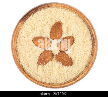 Top view of almond flour and a few grains of almonds on top of the flour. White background, copy space. Stock Photo