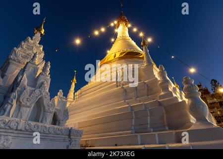 Buddhist stupa illuminated at dusk, Wat phrathat doi kongmu, Mae Hong Son, Thailand Stock Photo