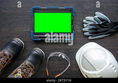 Digital tablet with layout and worker clothes, top view. Stock Photo