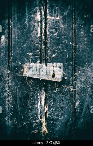 Old latch on a black door without the padlock Stock Photo