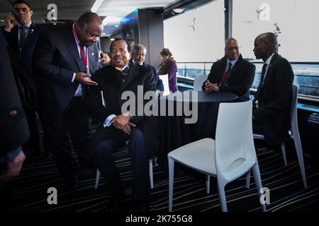 Gabonese President Ali Bongo Ondimba (L) speaks with Cameroon's President Paul Biya talk on the 'Mirage' boat which carries heads of state to the One Planet Summit on December 12, 2017, at La Seine Musicale venue on the ile Seguin in Boulogne-Billancourt, southwest of Paris.   Stock Photo